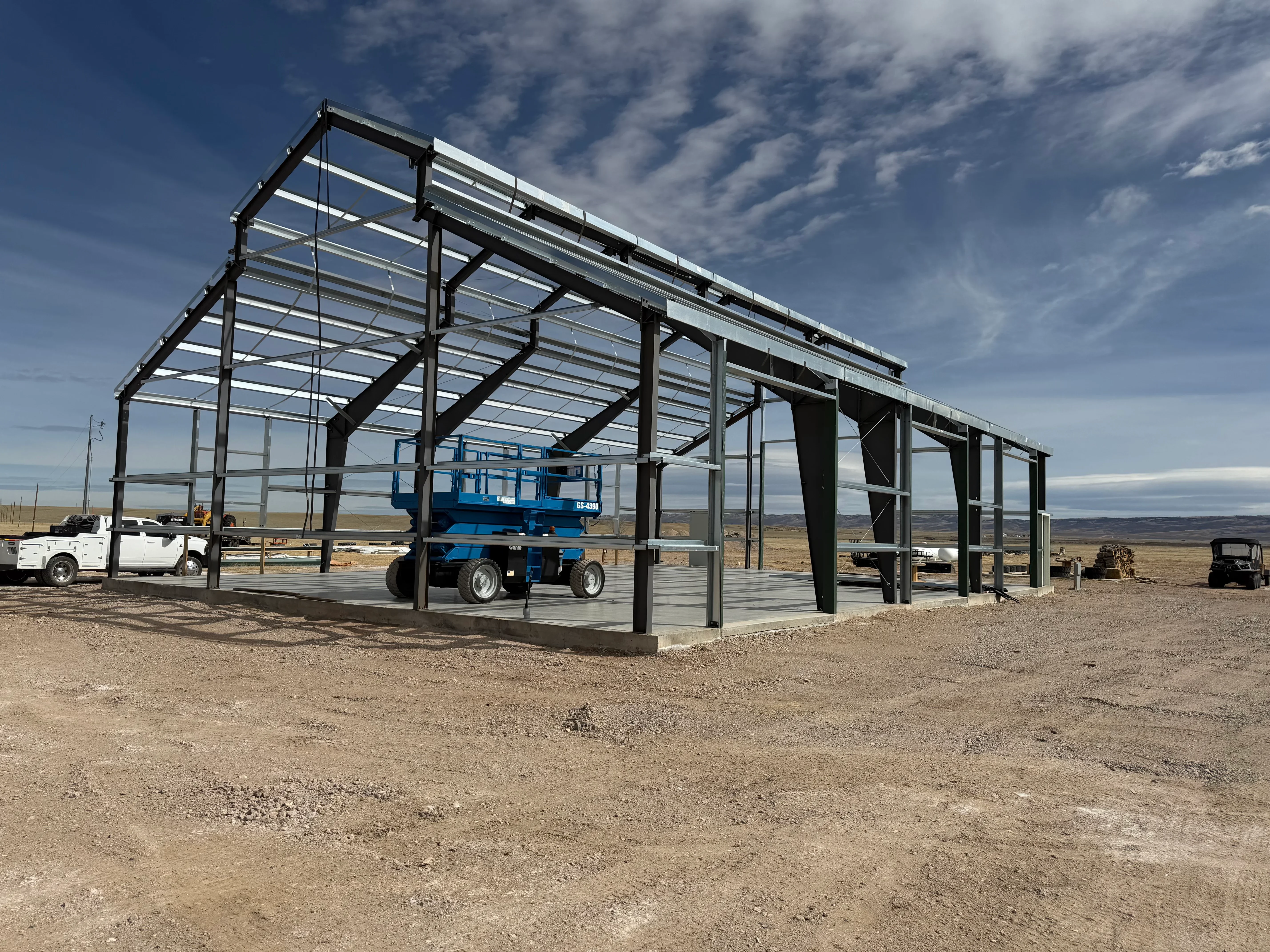 Steel frame building with corrugated metal roof and panels, open-sided design for equipment storage