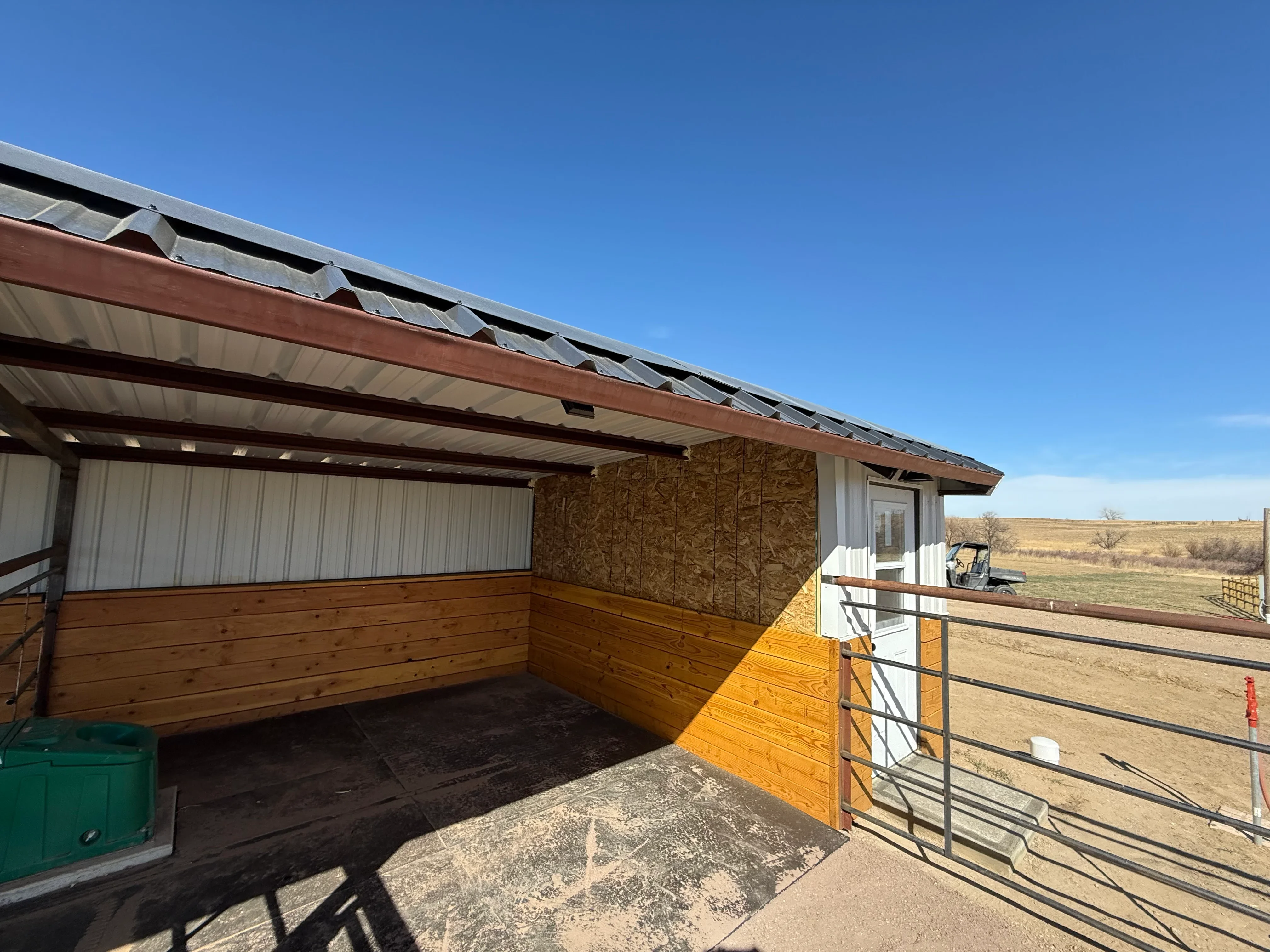 Metal building with corrugated roof, skylight vents, wood siding, and metal frame construction