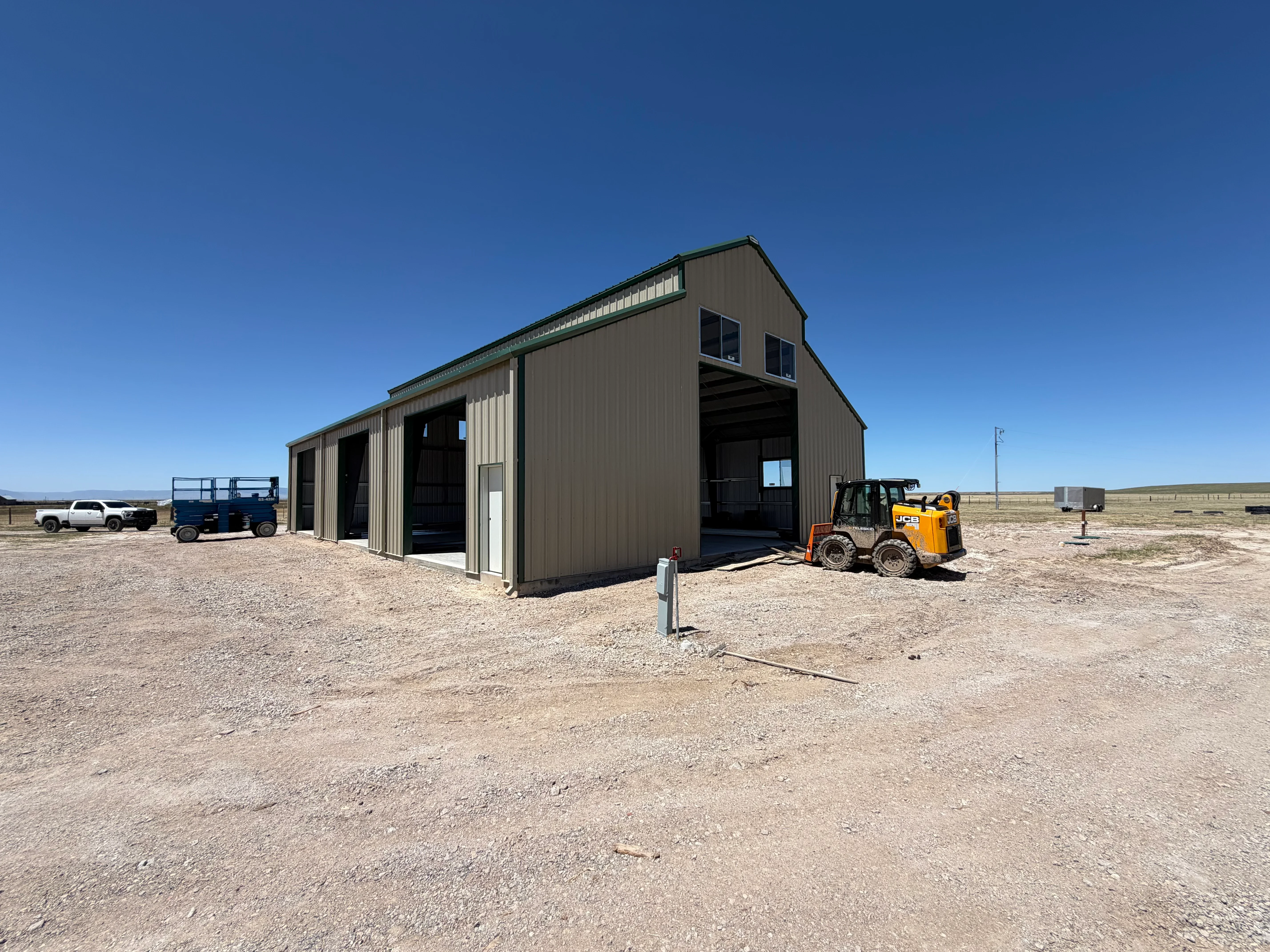 Charcoal and cream corrugated metal building with two drive-through bays and clerestory windows